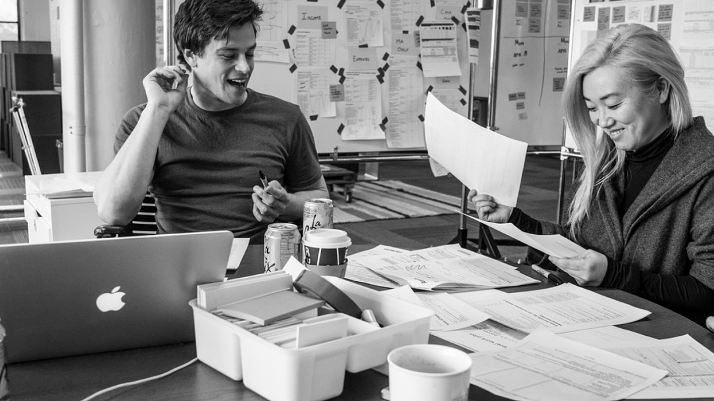 black and white photo of people working together at table