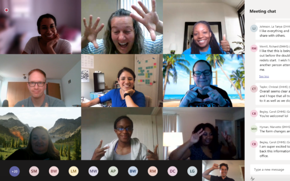 A virtual meeting with nine people smiling and making gestures, each in their own video frame. Chat messages and participants’ initials are visible on the right and bottom of the screen.