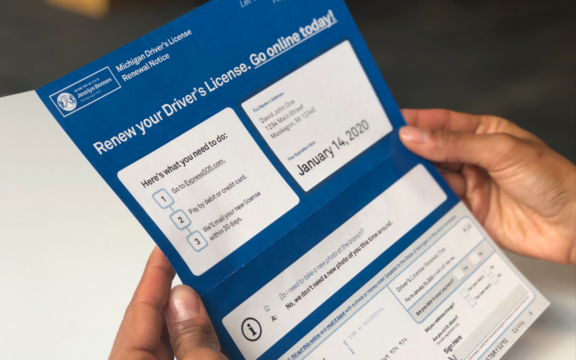A person holding a blue and white card.